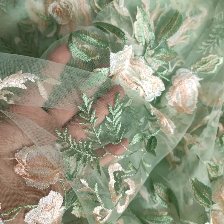 Tulle brodé floral au mètre de Longan Craft France, un tissu polyester vert transparent avec des broderies de fleurs blanches et beiges - parfait pour la couture de robes de mariée.