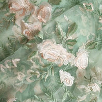 Tulle brodé floral au mètre de Longan Craft France, en polyester vert avec broderies roses et feuillages, idéal pour la couture de robe de mariée et un effet romantique délicat.