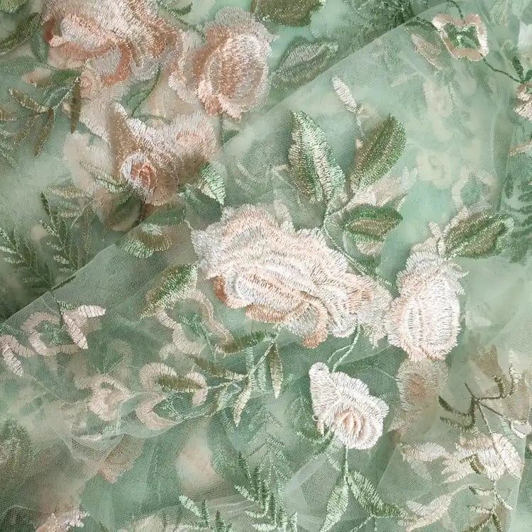 Tulle brodé floral au mètre de Longan Craft France, en polyester vert avec broderies roses et feuillages, idéal pour la couture de robe de mariée et un effet romantique délicat.