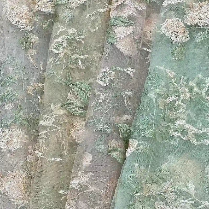 Le Tulle brodé floral au mètre de Longan Craft France - des panneaux transparents avec des broderies vertes, crème et beiges - apporte un style élégant à la couture nuptiale ou à tout autre espace.