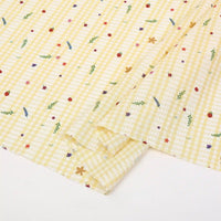 Le "Tissu pour patchwork Vichy au mètre" de Longan Craft France est un tissu polyester confortable avec un motif botanique de petites fleurs, de fraises et de feuilles vertes sur fond jaune et blanc, parfait pour les vêtements décontractés ou le quilting.