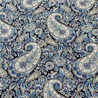Le Tissu motif paisley en coton imprimé floral au mètre de Longan Craft France présente des motifs floraux et ornementaux bleus, blancs et gris sur fond sombre, idéal pour créer des accessoires élégants avec un tissu léger et agréable au toucher.