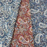 Trois pièces de "Tissu motif paisley en coton imprimé floral" par Longan Craft France : bleu et blanc, rouge et rose, et bleu foncé et bleu clair, chacune avec des motifs tourbillonnants et floraux complexes.