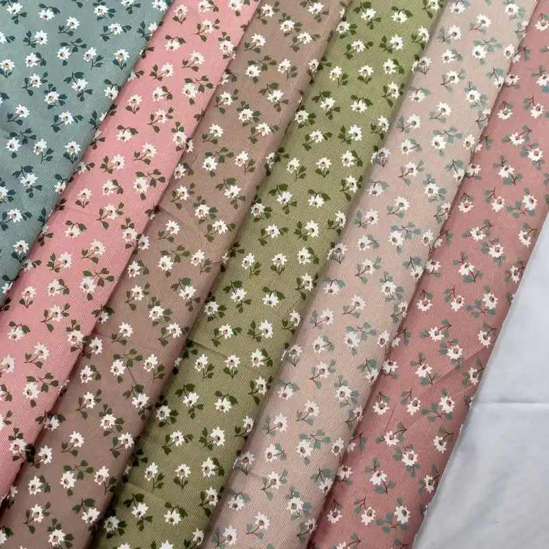 Six pièces de tissu peau de pêche imprimé floral au mètre Longan Craft France, en microfibre polyester pastel (bleu, rose, beige, vert, marron) à motifs fleurs blanches/feuilles vertes. Parfait pour couture ou accessoires charmants.