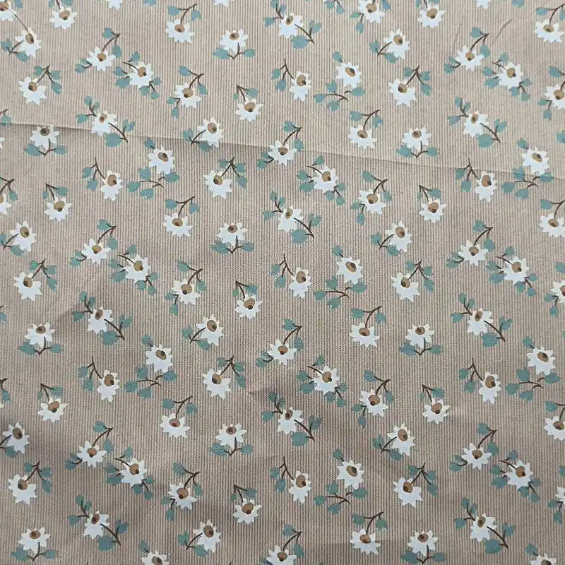 Le tissu peau de pêche imprimé floral de Longan Craft France est un microfibre polyester au mètre, confortable avec motif régulier fleurs blanches cœur brun et feuilles vertes, idéal pour la couture de vêtements.