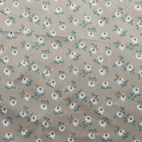 Le tissu peau de pêche imprimé floral de Longan Craft France est un microfibre polyester au mètre, confortable avec motif régulier fleurs blanches cœur brun et feuilles vertes, idéal pour la couture de vêtements.