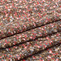 Gros plan sur le tissu en jersey coton imprimé fleurs et animaux de Longan Craft France, montrant des grappes denses de petites fleurs brunes, rouges, blanches et grises - idéal pour créer des robes et des vêtements uniques avec ce jersey au mètre 100 % coton.