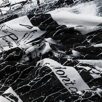 Gros plan sur le Tissu en jersey coton imprimé fleurs et animaux au mètre de Longan Craft France, un tissu en jersey 100 % coton pour robes et vêtements, avec des imprimés de fleurs et d'animaux et une texture légèrement froissée.