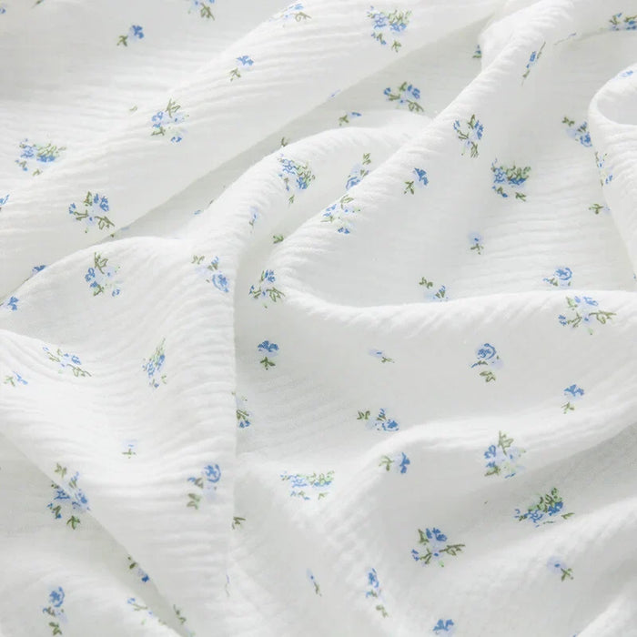 Double gaze de coton à fleurs bleues au mètre