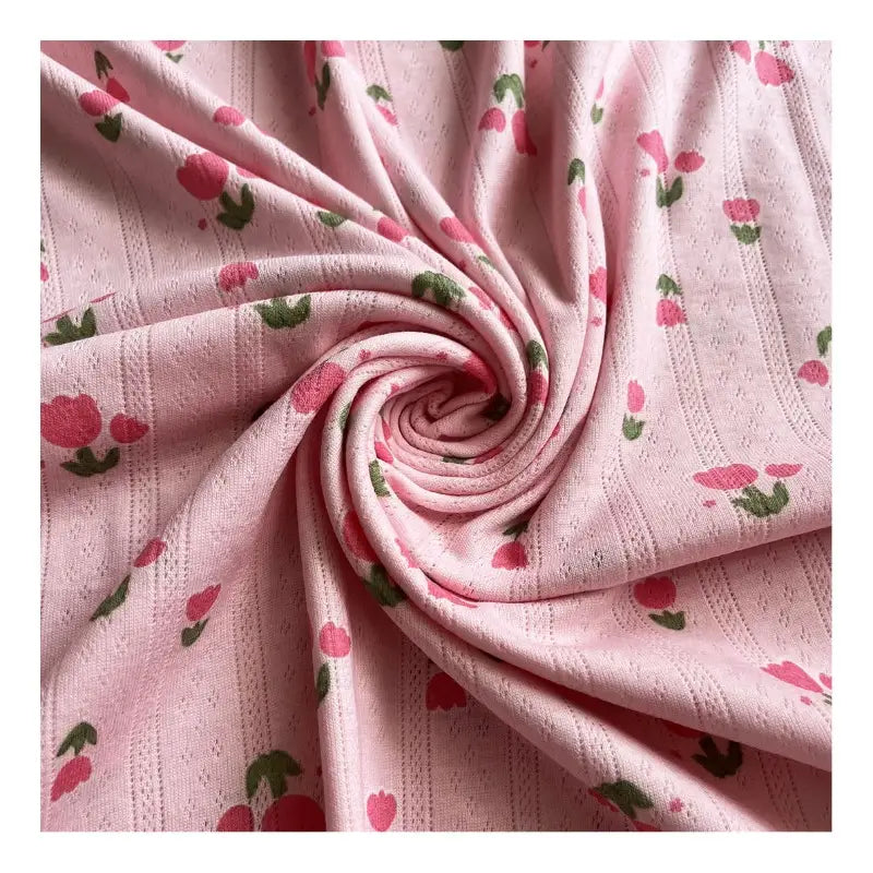 Maille pointelle imprimé tulipes de Longan Craft France : tissu jacquard doux à côtes verticales, motif fleuri rouge et vert sur fond rose, parfait pour DIY débardeurs, shorts ou ensembles pyjama. Vendu au mètre.