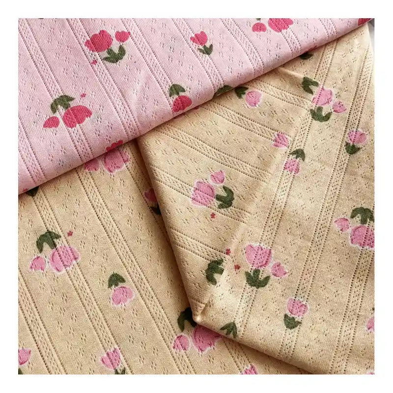 Deux pièces de Maille pointelle imprimée tulipes de Longan Craft France, en rose clair et beige, avec une texture pointillée subtile et un petit imprimé tulipe. Tissu jacquard idéal pour bricoler des tops, des shorts ou des pyjamas.