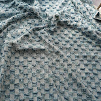 Gros plan sur le tissu denim à franges au mètre de Longan Craft France : un tissu doux et texturé avec des carreaux bleu clair en relief et effilochés, idéal comme tissu jean effiloché décoratif pour la couture.