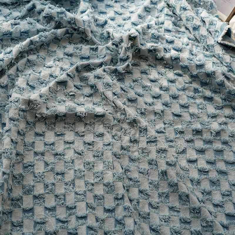 Gros plan sur le tissu denim à franges au mètre de Longan Craft France : un tissu doux et texturé avec des carreaux bleu clair en relief et effilochés, idéal comme tissu jean effiloché décoratif pour la couture.