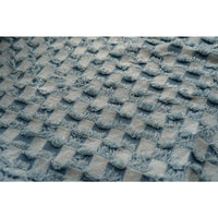 Gros plan sur le "Tissu denim à franges au mètre" de Longan Craft France, une toile de jean décorative et texturée avec des carrés doux en relief et des bords effilochés dans un bleu sourd, parfaite pour des projets de couture polyvalents.