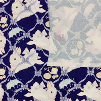 Le Tissu lapin de Pâques au mètre avec imprimé guirlande de Longan Craft France est un tissu 100 % coton doux et résistant, idéal pour vêtements d'enfants, avec des motifs lapins et accessoires sur fond bleu foncé.