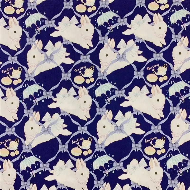 Un motif répétitif de lapins blancs avec des nœuds bleus, des tasses de thé, des biscuits et "tea time" sur un fond bleu foncé figure sur le tissu lapin de Pâques au mètre avec imprimé guirlande de Longan Craft France - 100 % coton, doux et durable, idéal pour les vêtements d'enfants.