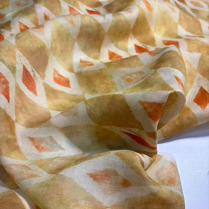 Gros plan sur le Tissu en ramie à imprimé géométrique au mètre de Longan Craft France, qui présente un motif de diamant léger et transparent en blanc, orange et jaune, idéal pour les robes d'été et les créations de couture.