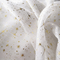 Le Tissu organza étoilé au mètre de Longan Craft France est un organza blanc imprimé de motifs étoiles dorées, souple et brillant, parfait pour la confection de robes de mariée et costumes de mariage.