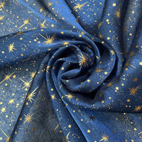 Le Tissu organza étoilé au mètre de Longan Craft France est un tissu organza imprimé bleu orné d'étoiles et de points dorés, idéal pour la confection de robes de mariée et de costumes.