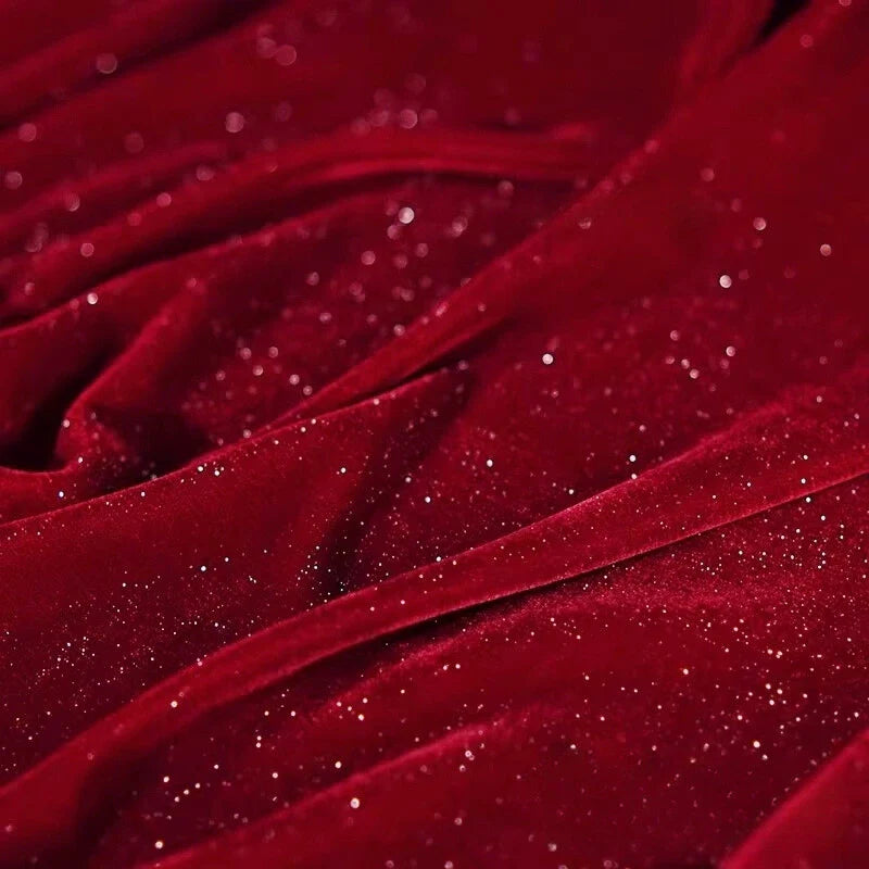 Un gros plan du Tissu velours pailleté au mètre de Longan Craft France révèle des velours de polyester rouge foncé avec des paillettes argentées, des plis doux et une texture riche - idéal pour les robes de soirée DIY, la décoration et les projets de couture.