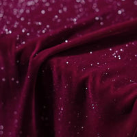 Gros plan sur le Tissu velours pailleté au mètre de Longan Craft France : un doux velours de polyester bordeaux parsemé de paillettes argentées, parfait pour les robes de soirée DIY et les décors de couture. Texture scintillante et luxueuse montrée en détail.