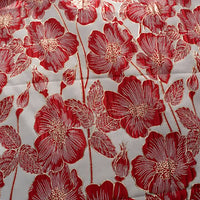 Gros plan sur le Tissu brocart floral 3D en fil d'or de Longan Craft France, un élégant tissu jacquard représentant de grandes fleurs rouges avec des contours blancs et des fils d'or sur un fond clair, avec à la fois des fleurs épanouies et des boutons fermés.