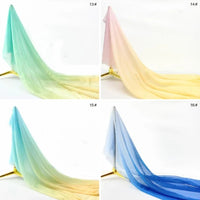Quatre drapés Mousseline transparente dégradée au mètre de Longan Craft France sont présentés : en haut à gauche vert-jaune, en haut à droite rose-jaune, en bas à gauche bleu-jaune, et en bas à droite bleu-clair dégradé.