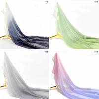 Quatre panneaux de Mousseline transparente dégradée au mètre de Longan Craft France - bleu foncé à blanc, vert clair, gris et rose passant au violet - sont présentés sur des présentoirs ; chaque panneau capte magnifiquement la lumière.
