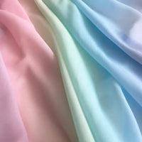 Découvrez le tissu en mousseline dégradé arc-en-ciel de Longan Craft France : doux, léger, aux tons pastel rose, vert et bleu, parfait pour robes, blouses et déco.