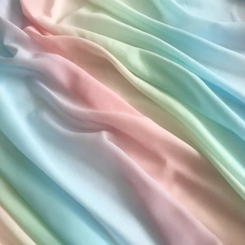 Tissu en mousseline dégradé arc-en-ciel au mètre de Longan Craft France - léger et soyeux avec un dégradé pastel de rose, bleu, vert et jaune, idéal pour robes, blouses ou déco.