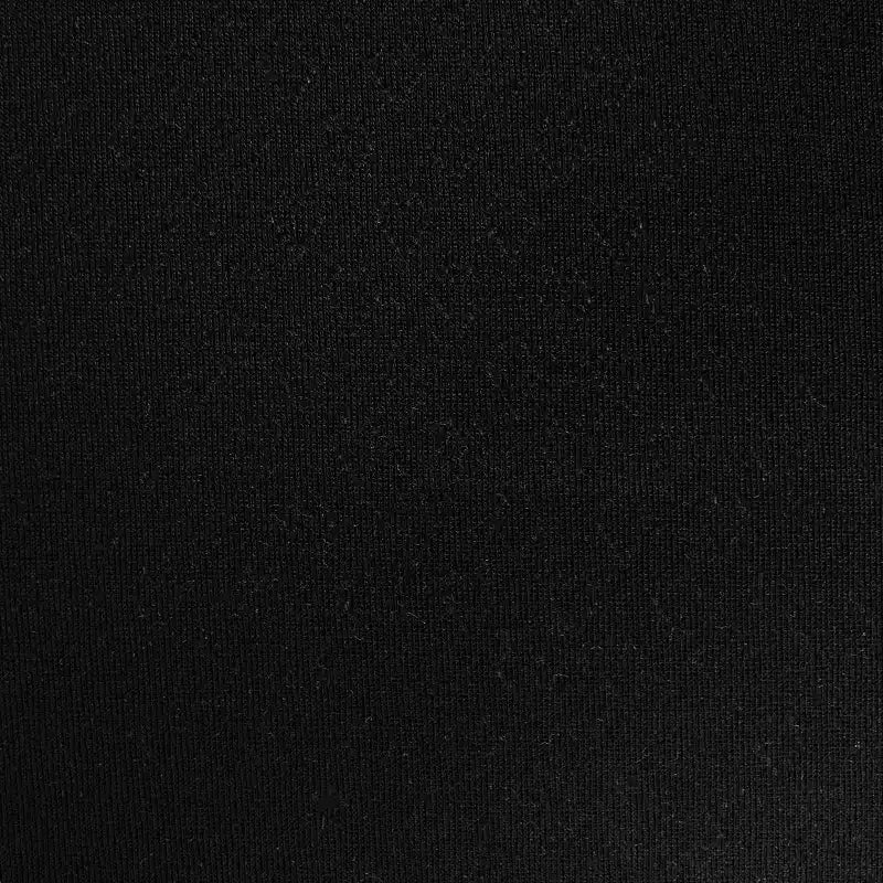 Gros plan sur le Tissu pointelle cœur au mètre de Longan Craft France, un tissu stretch noir, légèrement granuleux et mat. L'éclairage révèle sa texture subtile, ce qui le rend parfait pour les couches de base et les vêtements d'intérieur DIY.