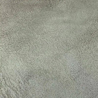 Un gros plan sur le Tissu suédine imprimé au mètre de Longon Craft France montre sa texture grise de velours suédine à motif litchi, subtilement craquelée et semblable à de la pierre, idéale pour les manteaux ou les canapés DIY.