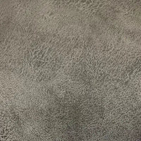 Un gros plan sur le tissu suédine imprimé au mètre de Longon Craft France montre un velours suédine texturé motif litchi en gris, idéal pour les manteaux ou les canapés DIY, avec un motif chiné et des nuances variées.