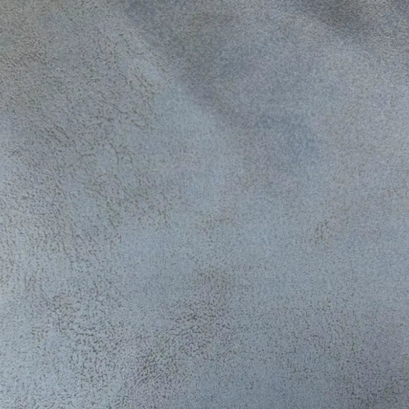 Gros plan sur le Tissu suédine imprimé au mètre de Longon Craft France, un tissu en daim gris à motif litchi idéal pour le bricolage, l'ameublement ou les manteaux, montrant de subtiles variations d'ombres et de fins motifs texturés.