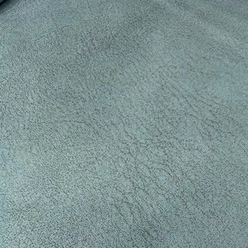 Un gros plan du tissu suédine imprimé au mètre de Longon Craft France montre un velours suédine gris clair avec de fines lignes irrégulières, une texture de motif litchi et un ombrage subtil - idéal pour les manteaux, les canapés ou les bricolages.