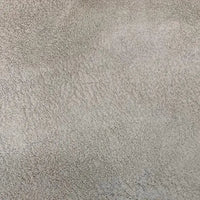 Gros plan sur le tissu suédine imprimé au mètre de Longon Craft France, un velours suédine motif litchi pour manteaux ou canapés. La surface beige texturée laisse apparaître de fins détails, parfaits pour les projets de bricolage tels que la tapisserie d'ameublement et la mode.