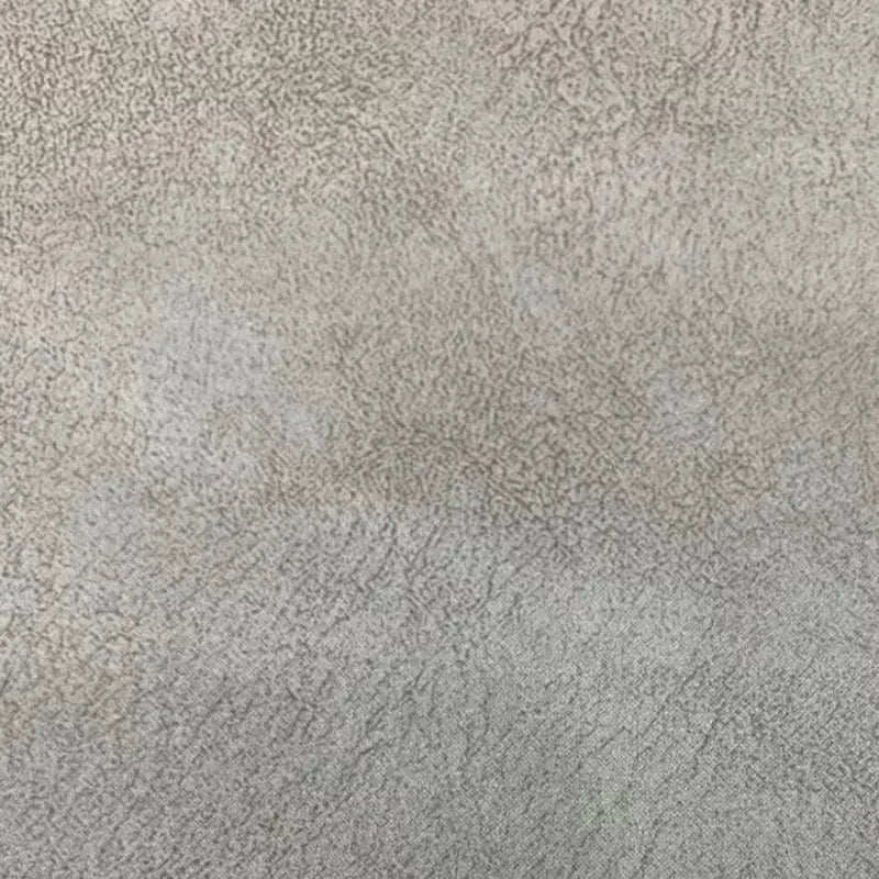 Gros plan sur le tissu suédine imprimé au mètre de Longon Craft France : velours suédine motif litchi pour manteau et canapé, idéal DIY. Polyester doux à l'aspect suede, surface texturée grise avec nuances subtiles et effet légèrement moucheté.