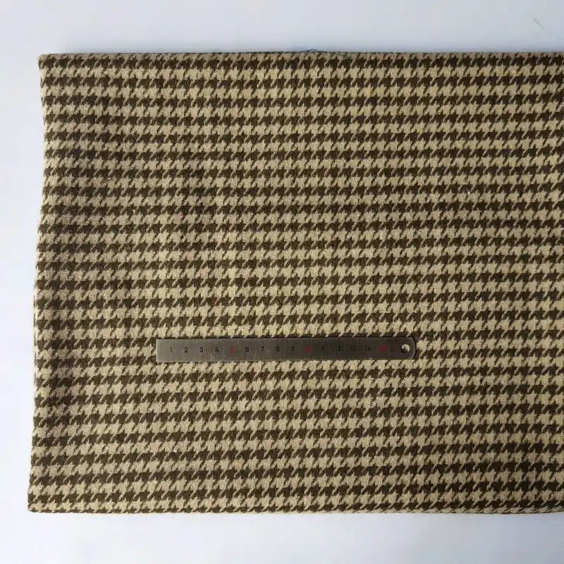 Un morceau rectangulaire de Tissu flanelle mammouth pied-de-poule de Longan Craft France est posé à plat sur une surface blanche, avec une règle en métal montrant l'échelle - flanellette idéale brossée en polyester coton pour des vêtements d'automne confortables.
