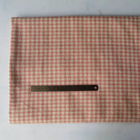 Un morceau de tissu flanelle mammouth pied-de-poule au mètre de Longan Craft France est posé à plat, avec une flanelle pied-de-poule rose et blanche, et une règle en métal sur le dessus pour l'échelle.