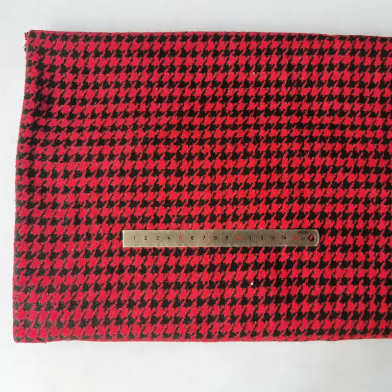 Un morceau de Tissu flanelle mammouth pied-de-poule au mètre de Longan Craft France est posé à plat, surmonté d'une règle métallique en centimètres, montrant le textile polyester-coton brossé rouge et noir de l'automne.