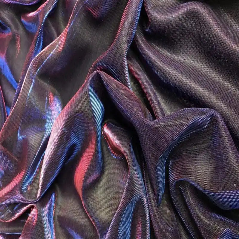 Gros plan sur le tissu en tulle bicolore irisé au mètre de Longan Craft France, un tissu de tulle soyeux et chatoyant destiné aux robes de chambre, montrant des plis irisés bleus et violets reflétant la lumière.