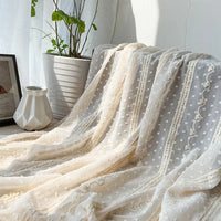 Tissu en mousseline jacquard à rayures et pois Longan Craft France drapé, créant une ambiance légère et élégante. À l'arrière-plan : pot blanc avec plante verte, cadre photo et vase céramique blanche pour la déco.