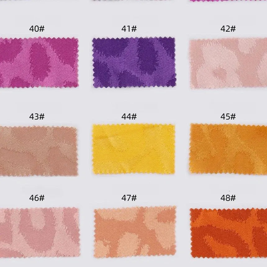 Douze échantillons de Tissu satin jacquard léopard au mètre de Longan Craft France, numérotés de 40# à 48#, sont présentés en rose, violet, jaune, orange et beige. Ce tissu satiné multicolore est idéal pour les chemises DIY et présente un motif animalier subtil.