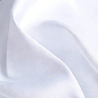 Gros plan sur le Tissu satin blanc uni au mètre de Longan Craft France, un textile de satin de polyester aux plis doux et aux ombres subtiles, idéal pour les robes et les vêtements élégants.