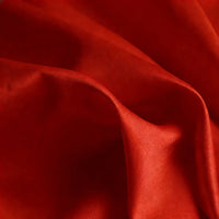Gros plan sur Tissu satin mat uni au mètre de Longan Craft France, un tissu polyester rouge aux plis visibles et à la texture lisse et douce, idéal pour les robes élégantes et les vêtements de style.