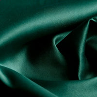 Gros plan sur le Tissu satin mat uni au mètre de Longan Craft France, un tissu de satin de polyester d'un vert profond à la texture lisse et brillante et au drapé élégant, idéal pour les peignoirs et les vêtements sophistiqués.
