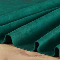 Gros plan sur la matière suédine microfibre au mètre de Longan Craft France, un tissu micro suédine extensible ultra doux et extensible dans les 4 sens, drapé en plis doux sur du bois - parfait pour les projets de vêtements DIY.
