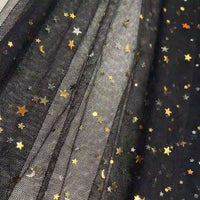 Le Tissu tulle lune et étoiles au mètre de Longan Craft France est un tulle noir multicolore pailleté, orné d'étoiles dorées et argentées, de pois et de croissants de lune. Idéal pour les costumes de scène ou la confection de robes.