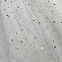 Le Tissu tulle lune et étoiles au mètre de Longan Craft France est un tulle transparent pailleté multicolore avec de délicats motifs d'étoiles et de lunes dorées, parfait pour les costumes de scène, présenté ici à plat en plis souples et translucides.