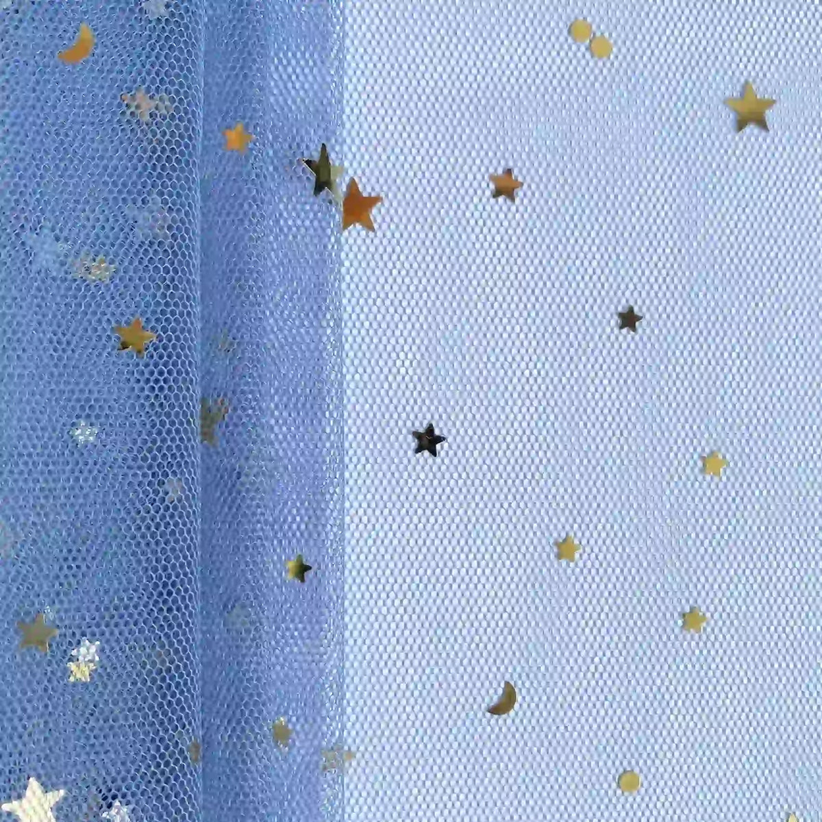 Un gros plan du "Tissu tulle lune et étoiles au mètre" de Longan Craft France montre des confettis d'étoiles et de lunes dorées sur une maille pailletée multicolore, idéale pour les costumes de scène. L'éclairage uniforme révèle la texture détaillée du tulle.
